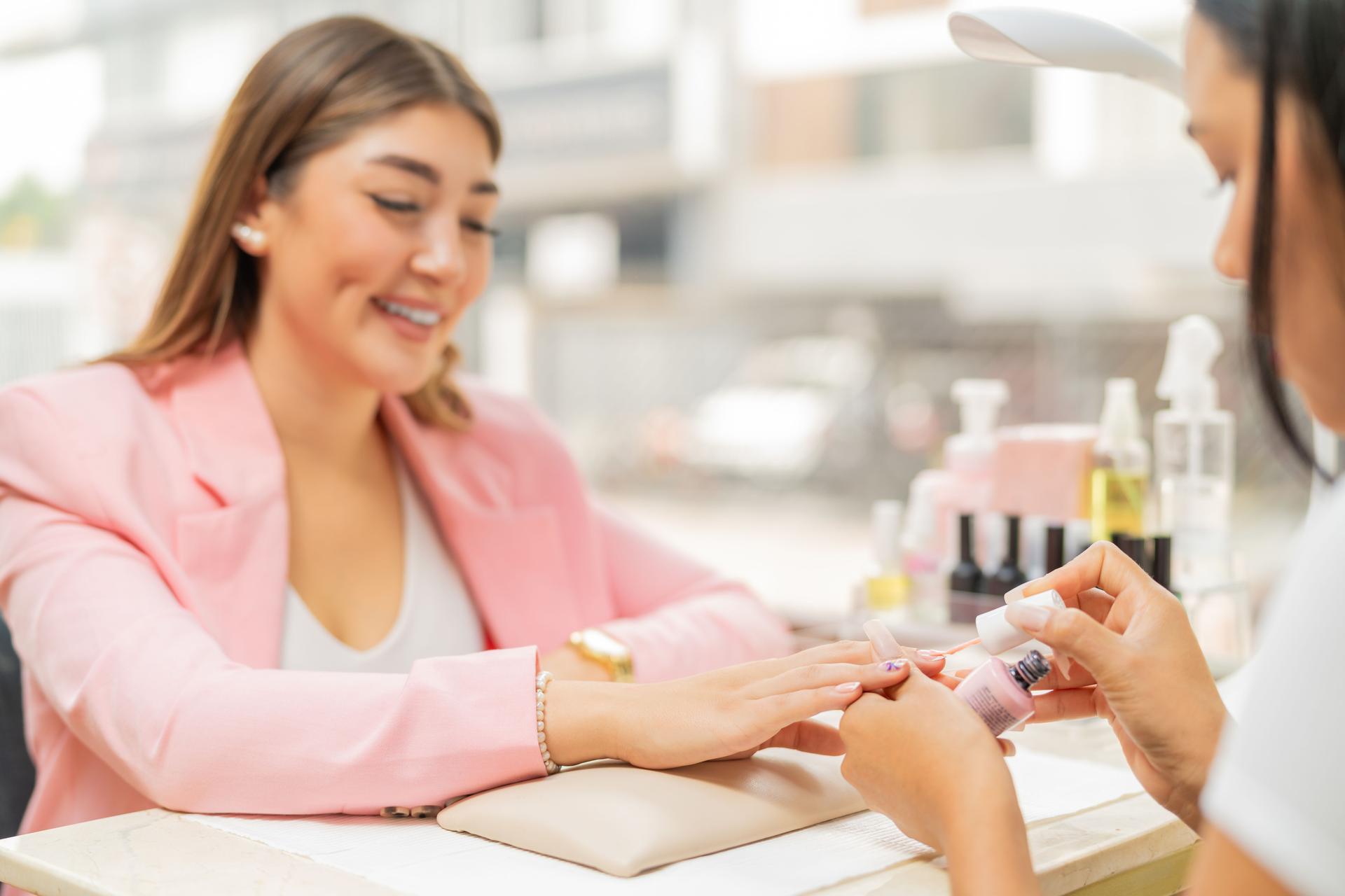 Smiling client in a beauty salon painting her nails